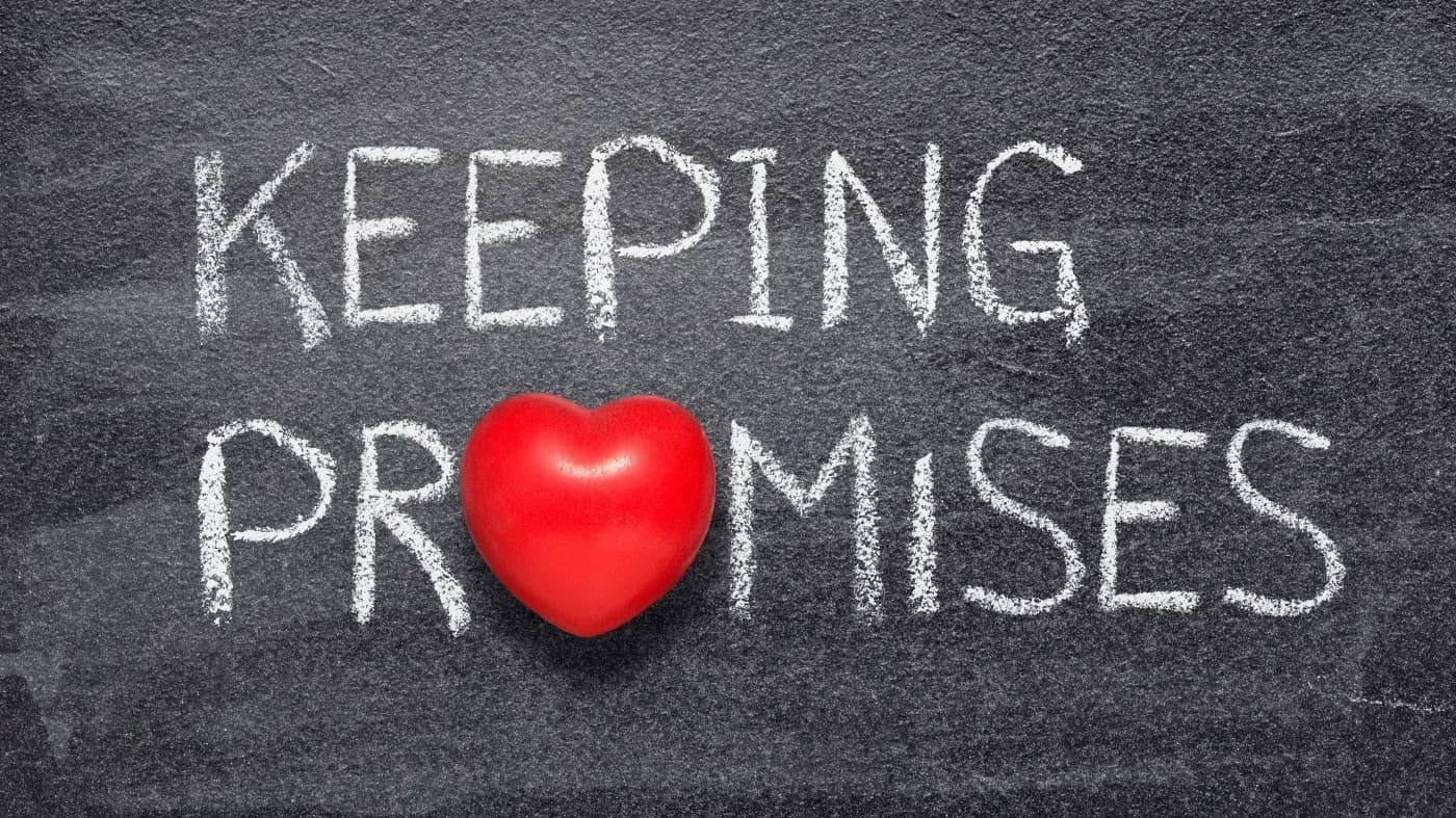 Chalkboard with the phrase "Keeping Promises" in white chalk. A red heart symbol replaces the "O" in "Promises," adding a sense of love and commitment.