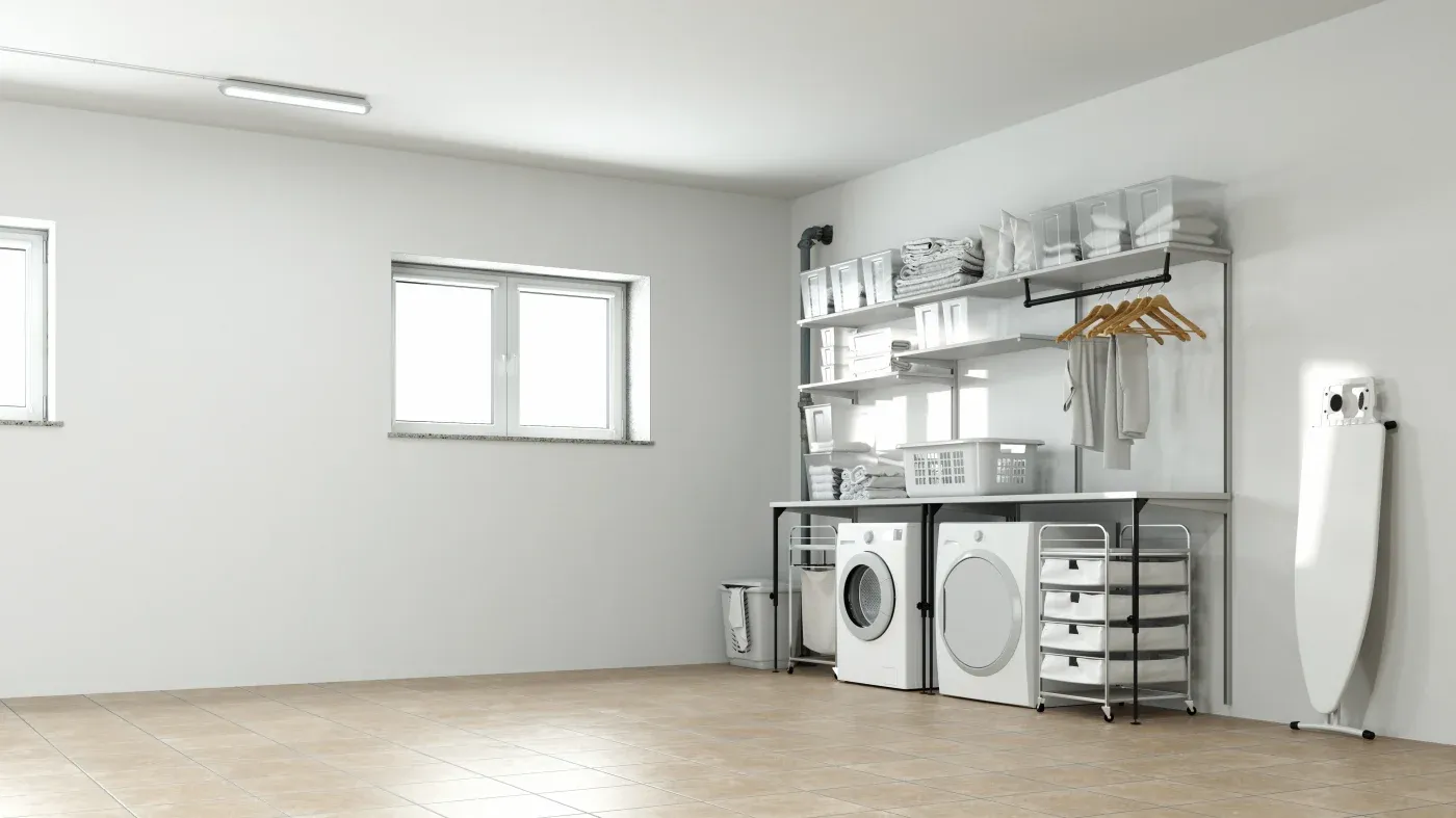 Minimalist laundry room with a washing machine and dryer, shelves with folded towels, hangers, and storage bins. An ironing board stands nearby.