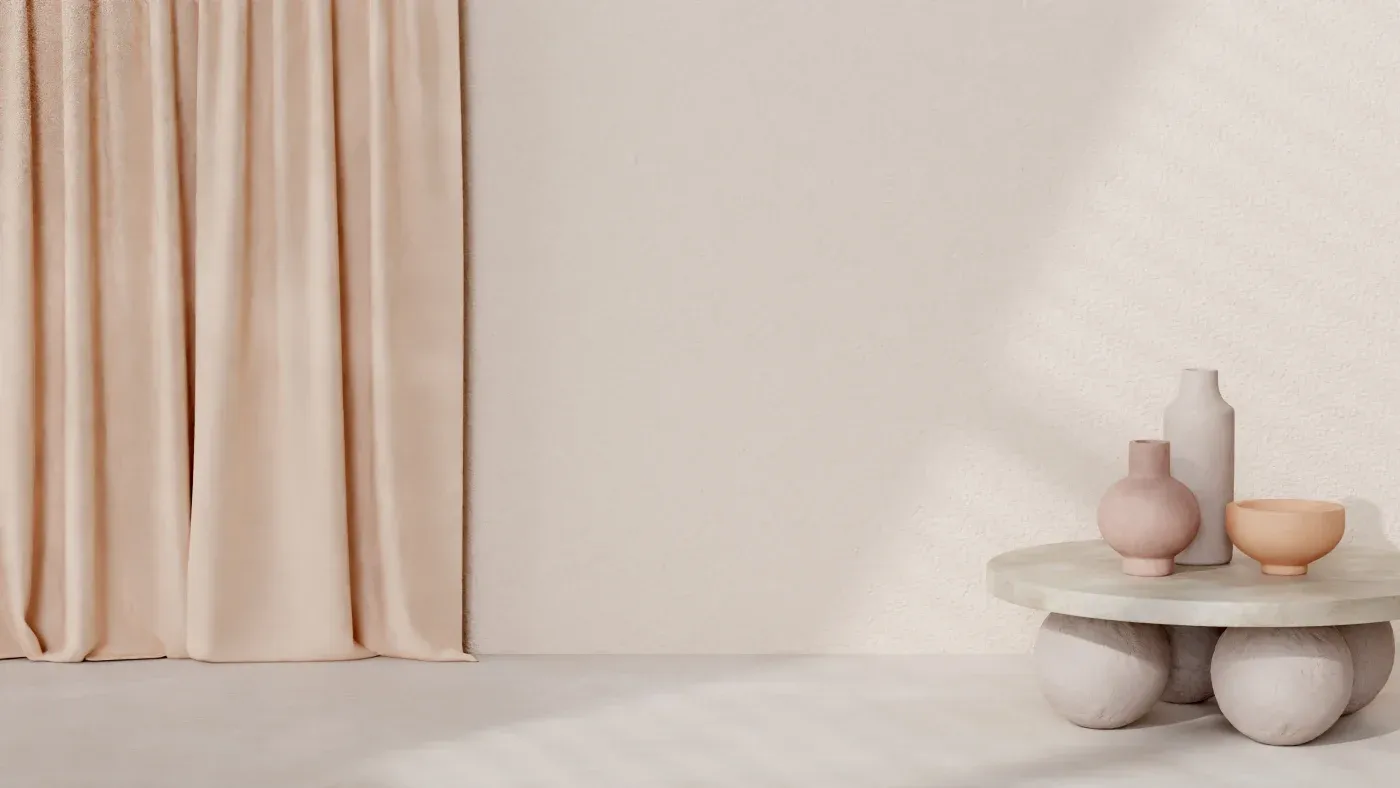 A minimalist beige room features soft peach curtains on the left and a round stone table with three ceramic vases, casting gentle shadows on the right.