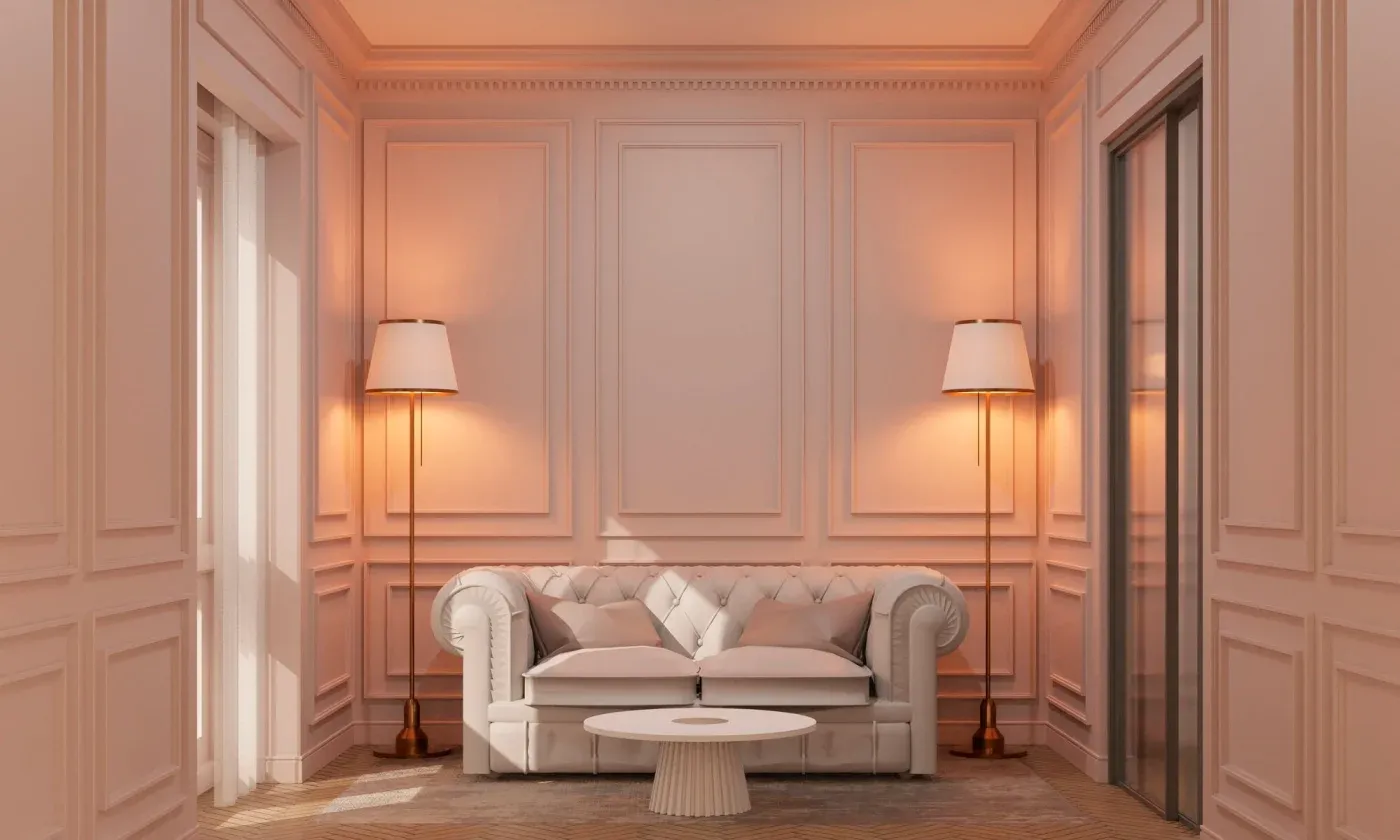 Elegant living room with a soft beige palette features a tufted sofa, round coffee table, and two tall lamps, conveying a cozy, sophisticated ambiance.